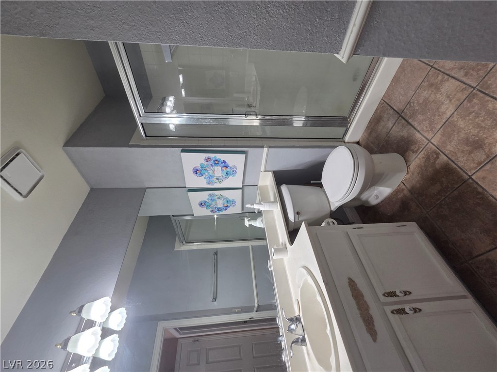 1429 Hawkwood Road Henderson, NV 89014 - Photo 44 of 53 Tiled flooring and a glass-enclosed shower stall complete this functional bathroom space.