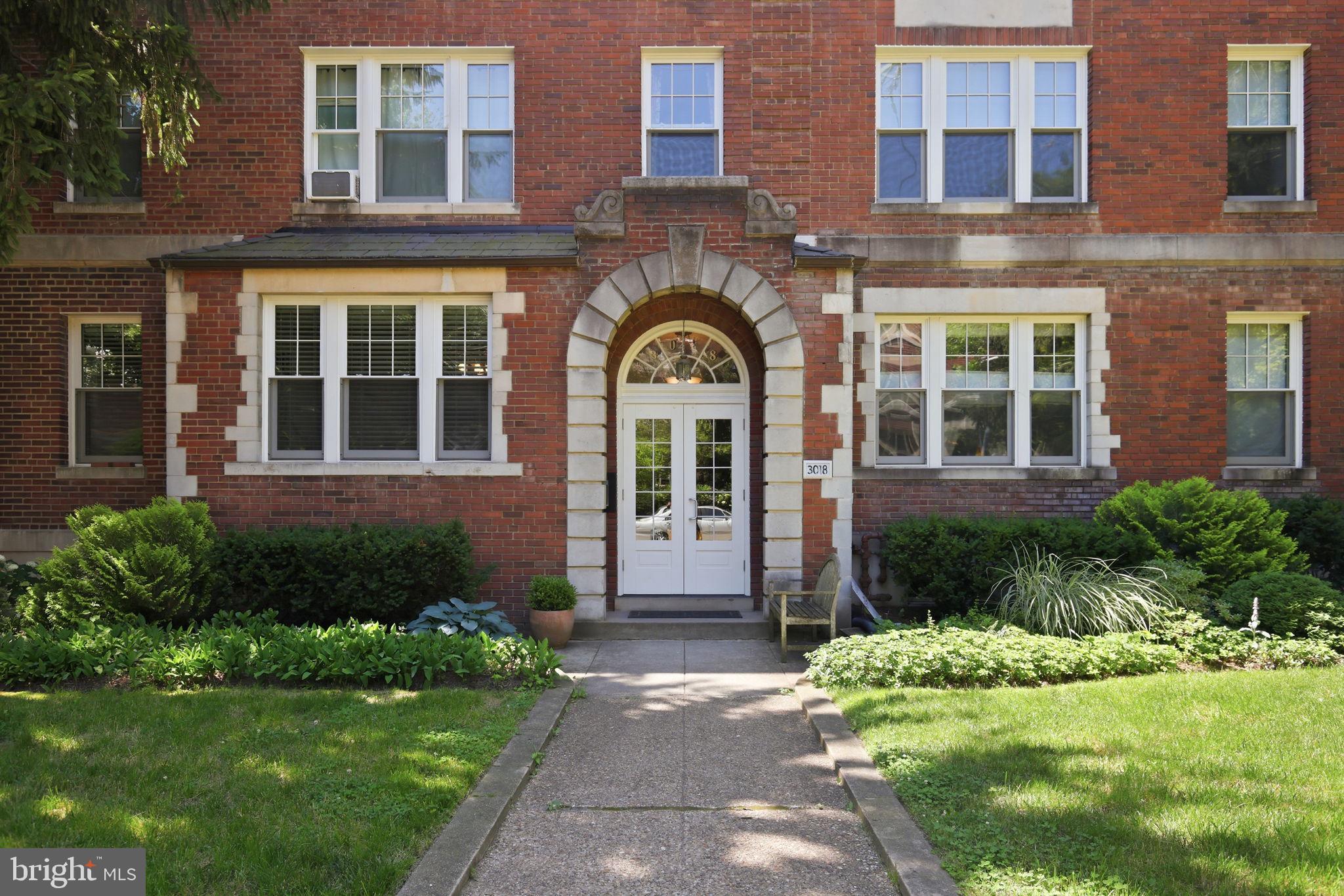 3018 Porter Street Northwest, Unit 103 Washington, DC 20008 - Photo 3 of 27 Charming brick facade with lush greenery.