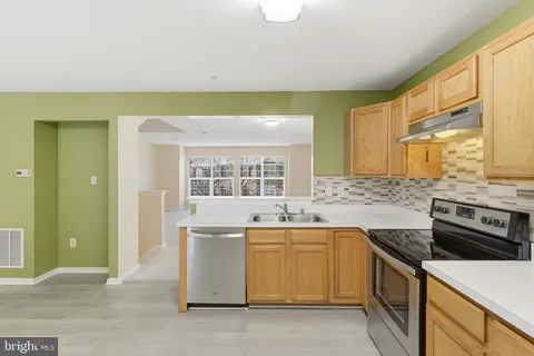 a kitchen with stainless steel appliances a stove a sink and a refrigerator