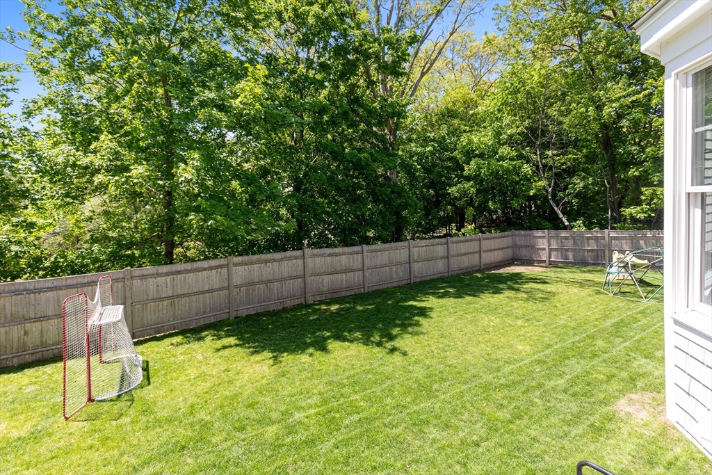 65 Bel Air Road Hingham, MA 02043 - Photo 33 of 35 a view of a backyard with a small cabin and a chair