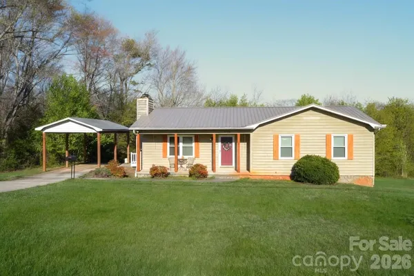 a front view of a house with a yard and trees