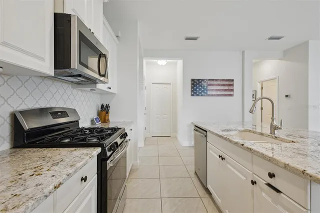 a kitchen with stainless steel appliances granite countertop a sink stove and cabinets