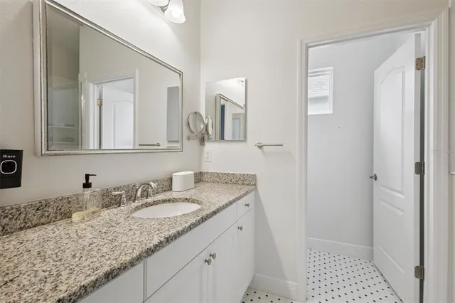 a bathroom with a granite countertop sink and a mirror