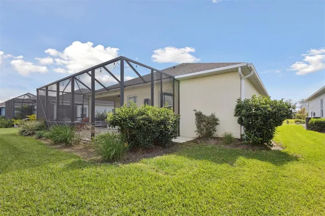 a view of a house with brick walls and a yard with plants
