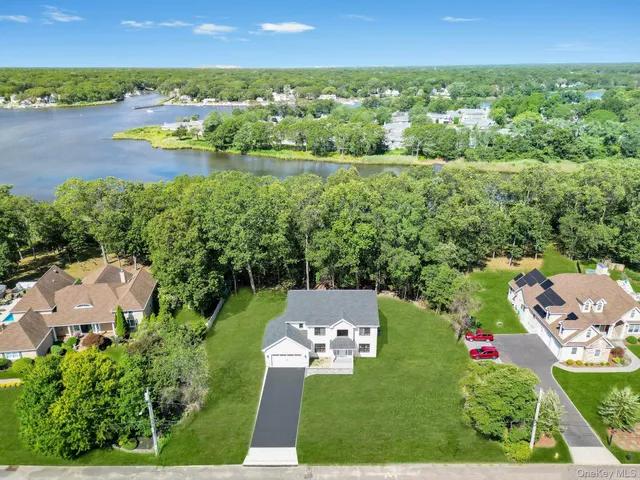 an aerial view of residential houses with outdoor space and lake view
