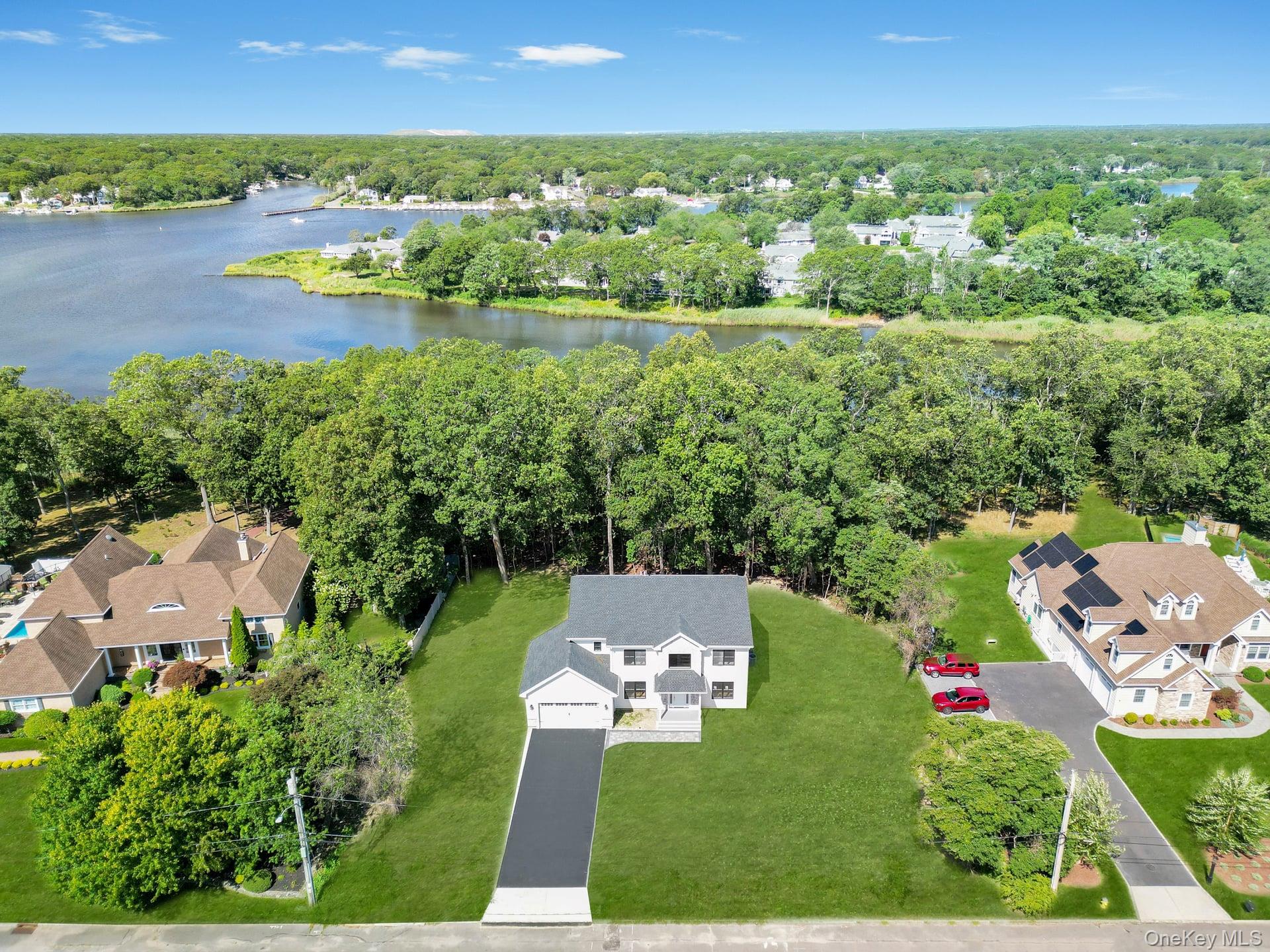 an aerial view of residential houses with outdoor space and lake view