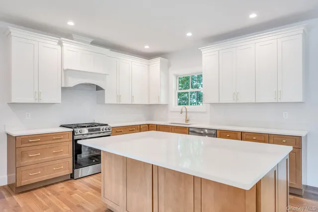 a kitchen with stainless steel appliances granite countertop a sink and a stove with white countertops