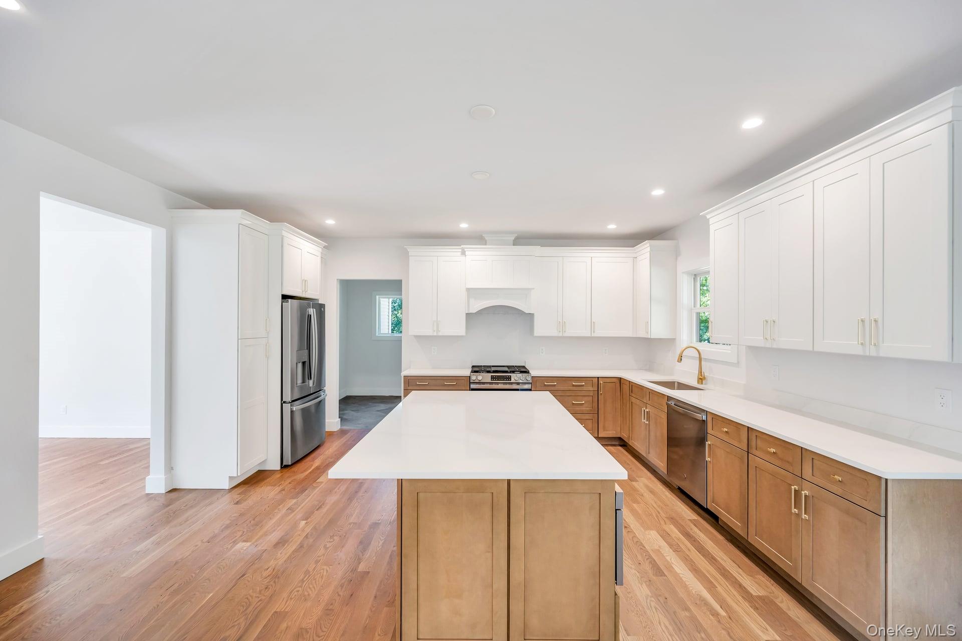84 James Hawkins Road Moriches, NY 11955 - Photo 14 of 50 a kitchen with stainless steel appliances granite countertop a refrigerator a sink dishwasher a stove and white countertops with wooden floor