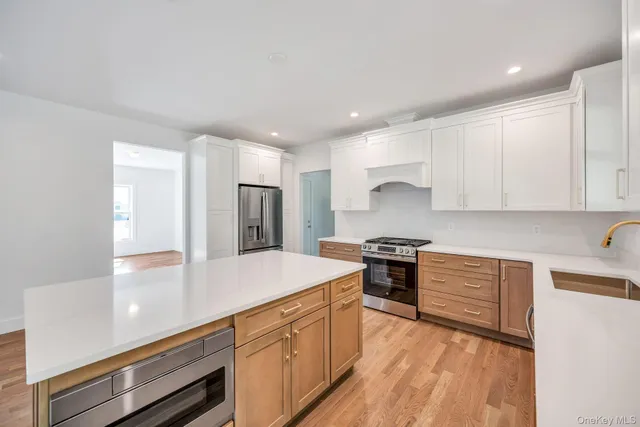 a kitchen with stainless steel appliances granite countertop a sink stove and refrigerator