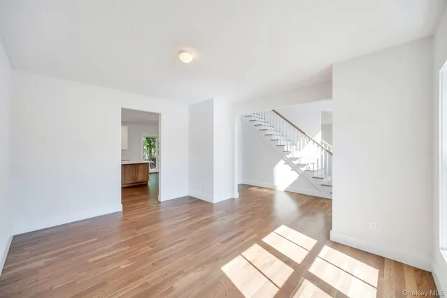 a view of a big room with wooden floor and windows