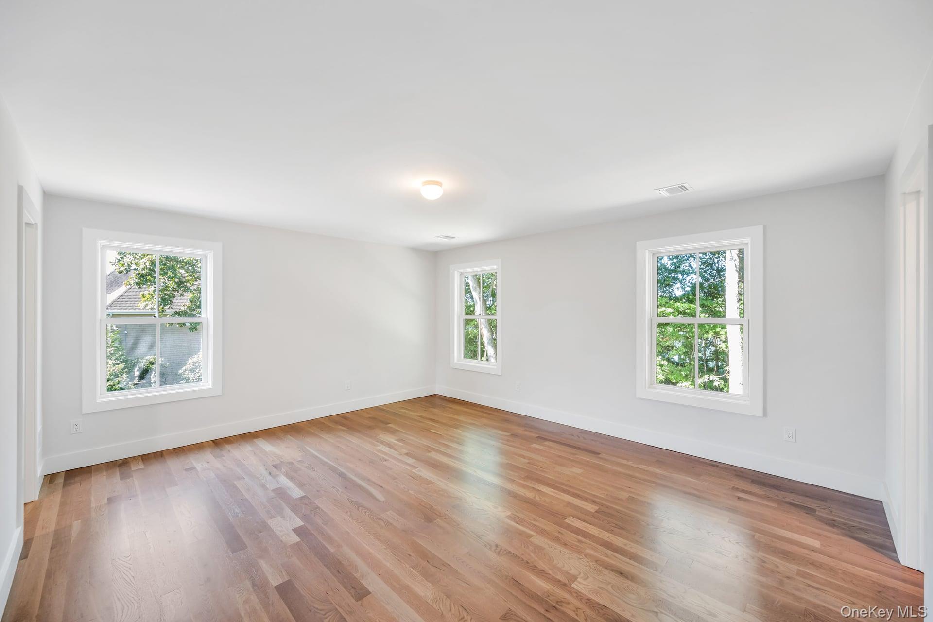 84 James Hawkins Road Moriches, NY 11955 - Photo 35 of 50 an empty room with wooden floor and windows