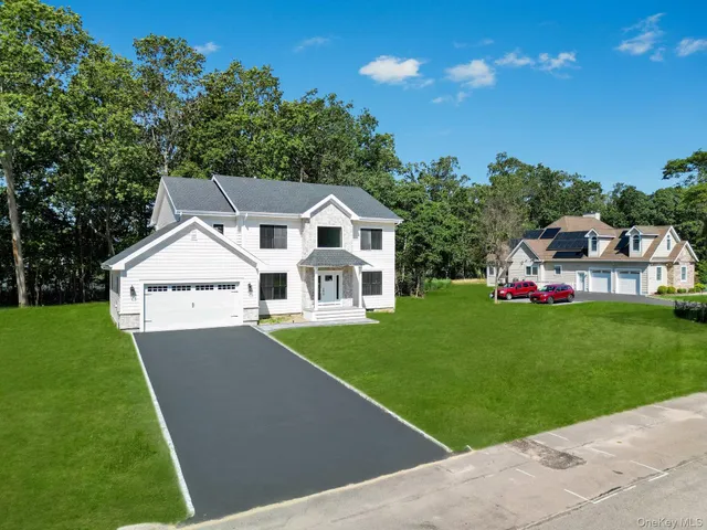 a front view of a house with a garden and yard