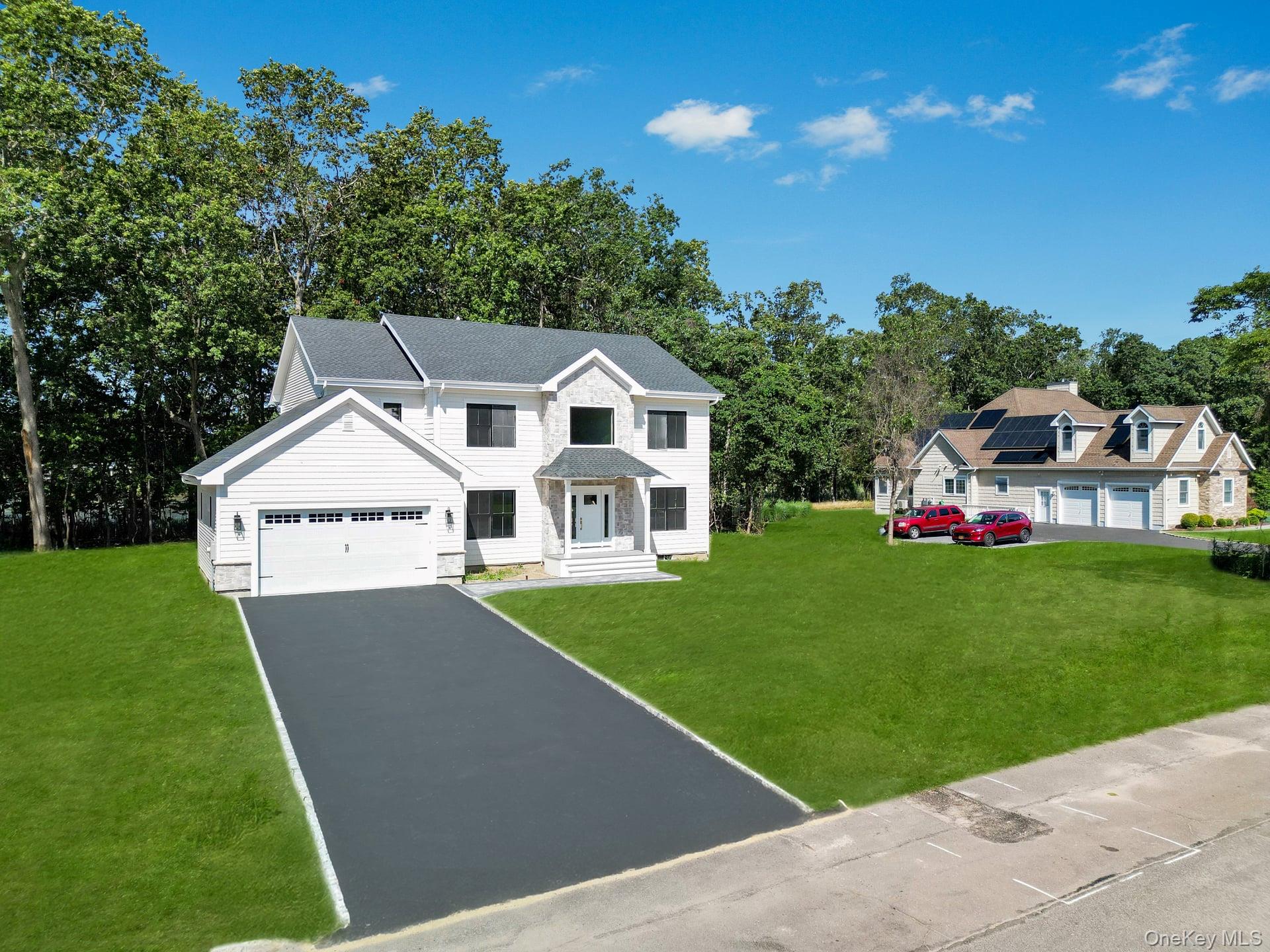 84 James Hawkins Road Moriches, NY 11955 - Photo 4 of 50 a front view of a house with a garden and yard