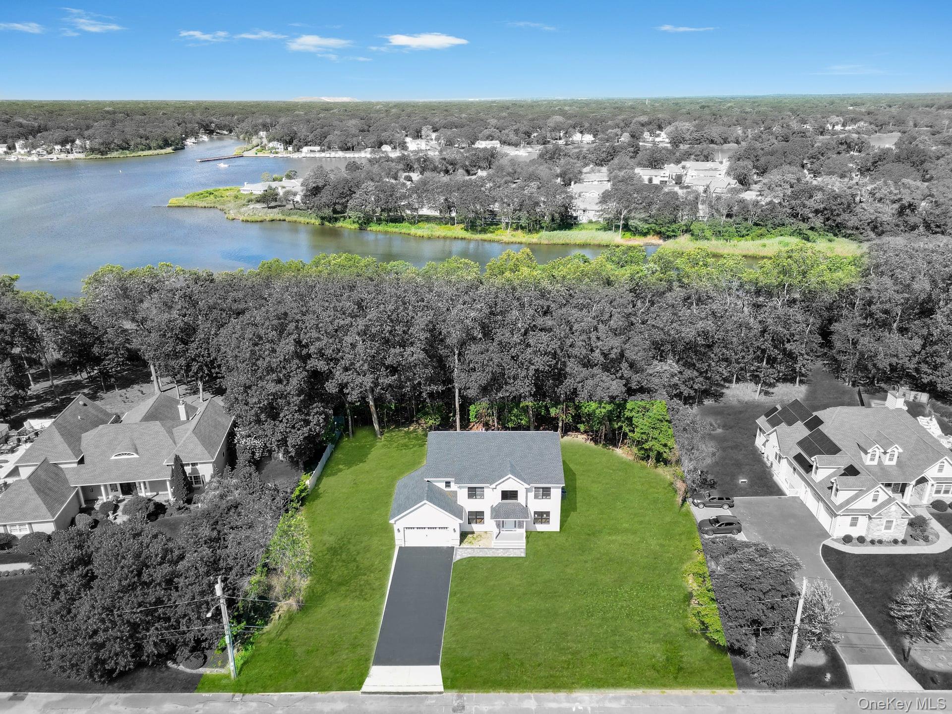 84 James Hawkins Road Moriches, NY 11955 - Photo 6 of 50 an aerial view of a city with lots of residential buildings and lake view in back
