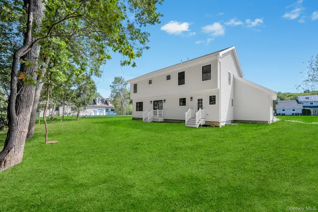 a view of a white house with a big yard