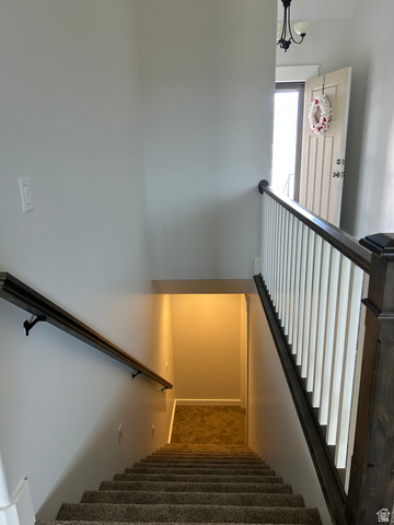 175 North 100th West Centerfield, UT 84622 - Photo 27 of 32 Carpeted staircase featuring a dark wood railing and white balusters. Headed toward basement.