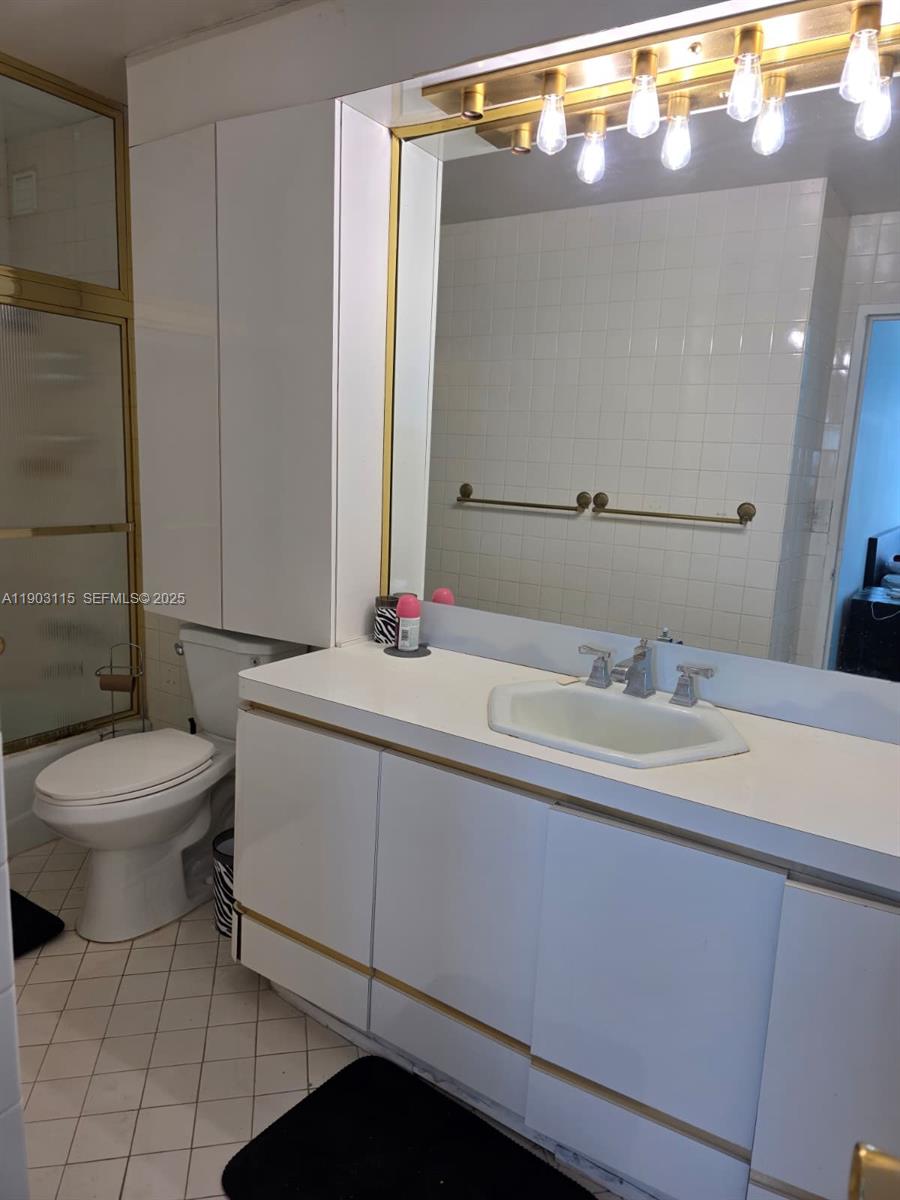 9102 West Bay Harbor Drive, Unit 4C Bay Harbor Islands, FL 33154 - Photo 14 of 26 a bathroom with a sink a toilet and mirror