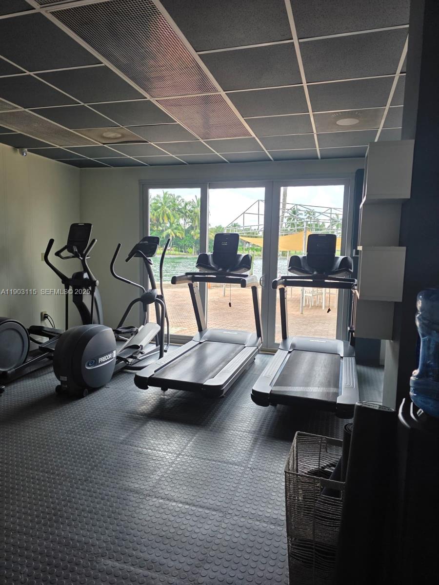 9102 West Bay Harbor Drive, Unit 4C Bay Harbor Islands, FL 33154 - Photo 18 of 26 a room with gym equipment and a large window