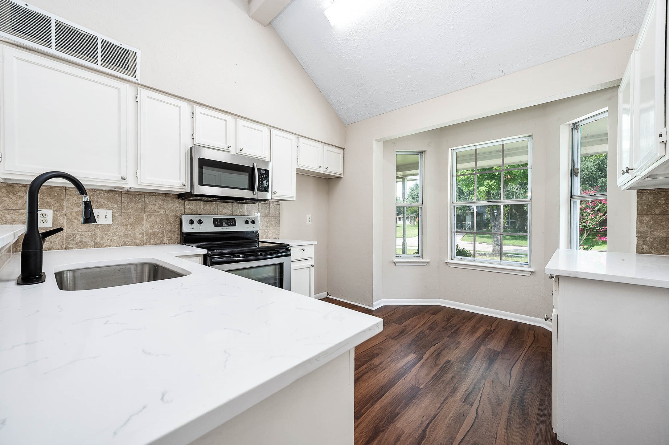 915 West Primrose Meadows Circle Pearland, TX 77584 - Photo 11 of 31 a kitchen with stainless steel appliances a stove microwave and sink