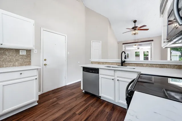 a kitchen with a sink cabinets and wooden floor