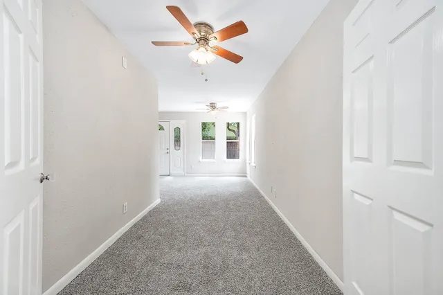 an empty room with chandelier fan