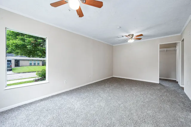 an empty room with windows and fan