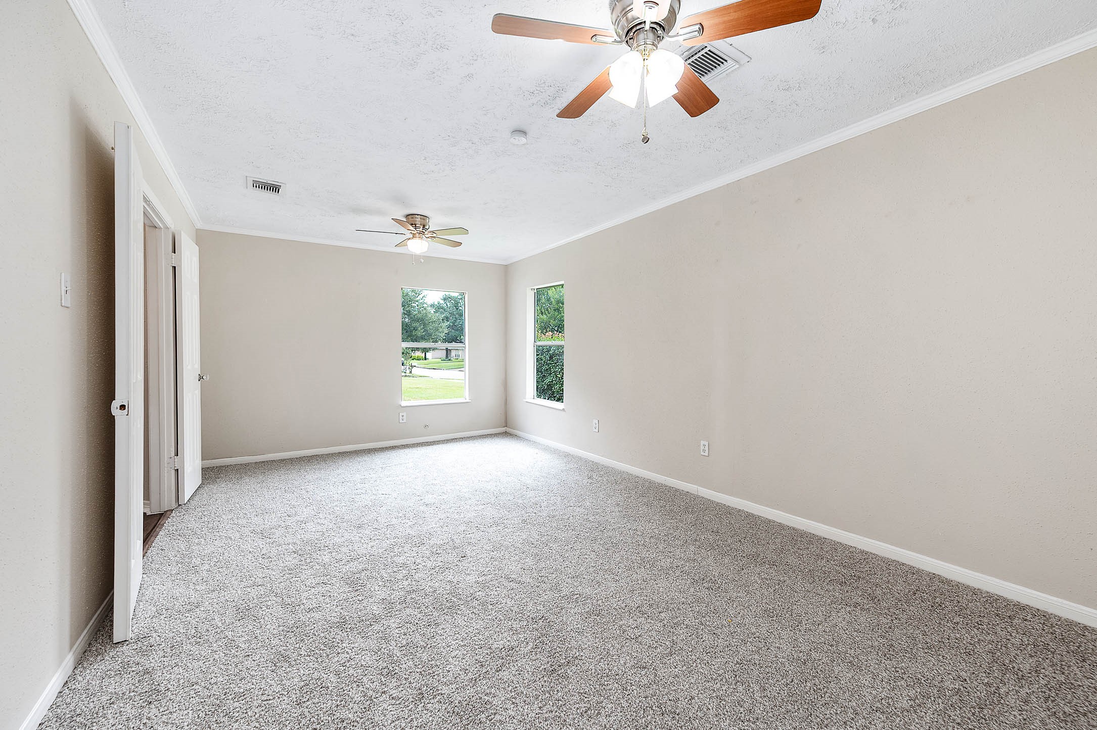 915 West Primrose Meadows Circle Pearland, TX 77584 - Photo 21 of 31 an empty room with windows and chandelier fan