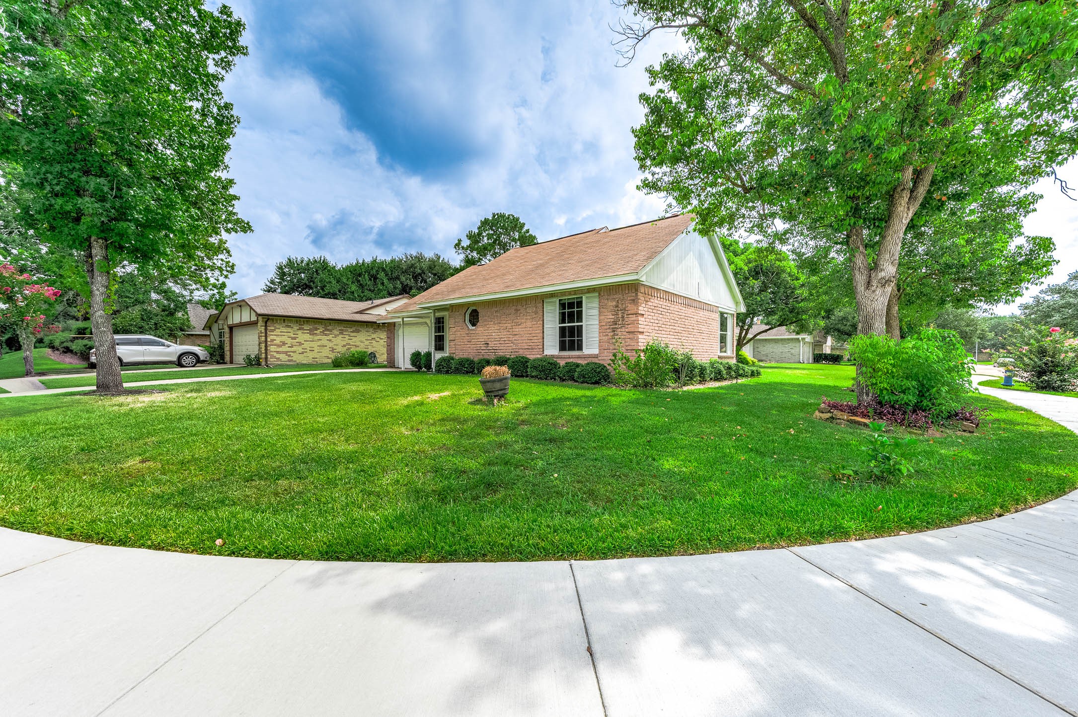 915 West Primrose Meadows Circle Pearland, TX 77584 - Photo 3 of 31 a backyard of a house with potted plants and large trees