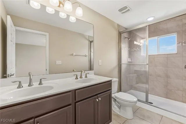 a bathroom with a double vanity sink mirror and toilet