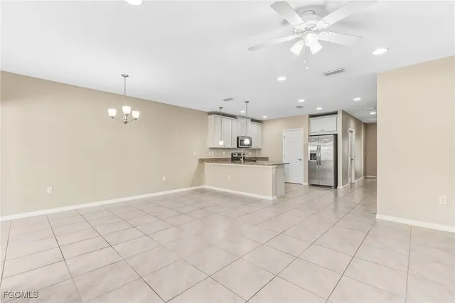 a view of a kitchen with kitchen island white cabinets and stainless steel appliances