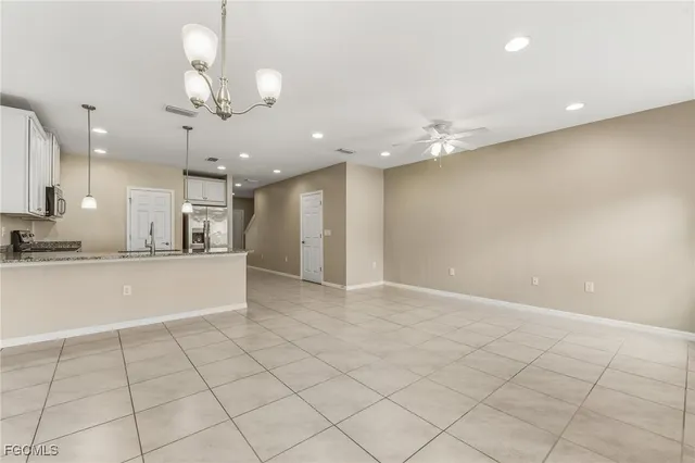 a view of an empty room and kitchen view