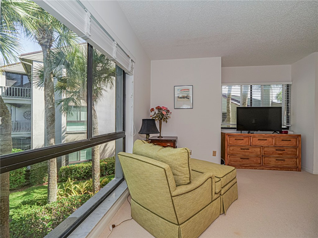 1001 Bay Road, Unit 205 Vero Beach, FL 32963 - Photo 17 of 36 a living room with furniture a flat screen tv and a floor to ceiling window