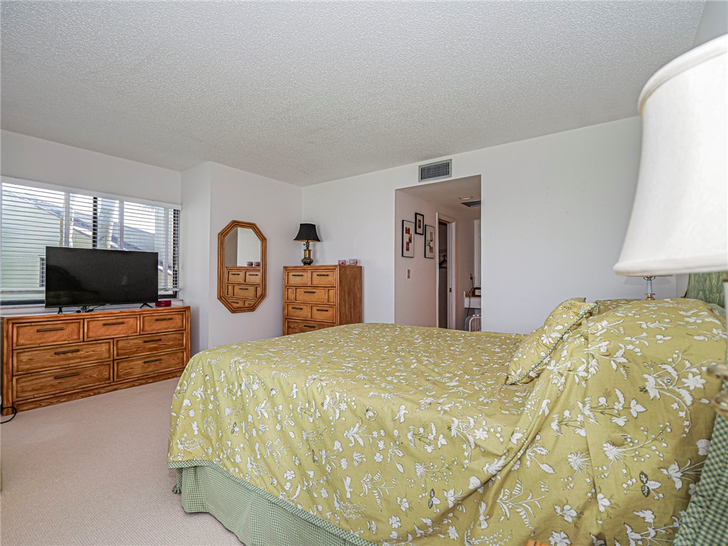 1001 Bay Road, Unit 205 Vero Beach, FL 32963 - Photo 18 of 36 a bedroom with a bed and a flat screen tv