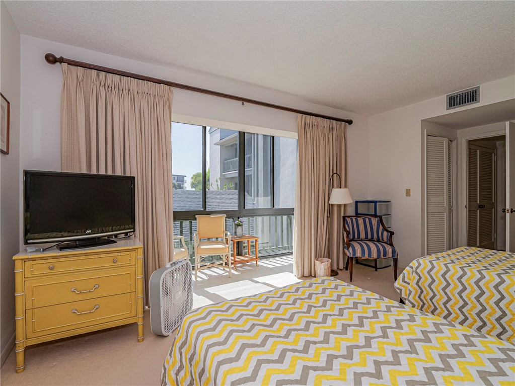 1001 Bay Road, Unit 205 Vero Beach, FL 32963 - Photo 24 of 36 a bedroom with a bed and flat screen tv