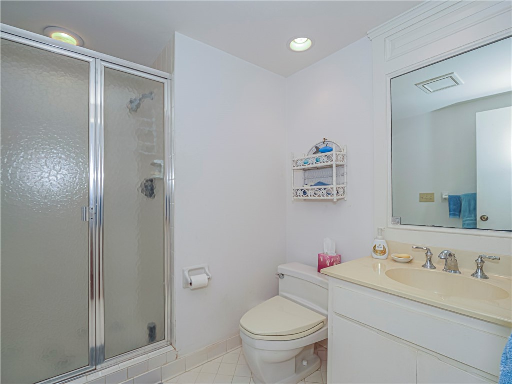1001 Bay Road, Unit 205 Vero Beach, FL 32963 - Photo 26 of 36 a bathroom with a granite countertop sink toilet and a shower