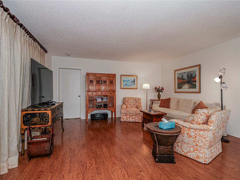 1001 Bay Road, Unit 205 Vero Beach, FL 32963 - Photo 9 of 36 a living room with furniture and wooden floor