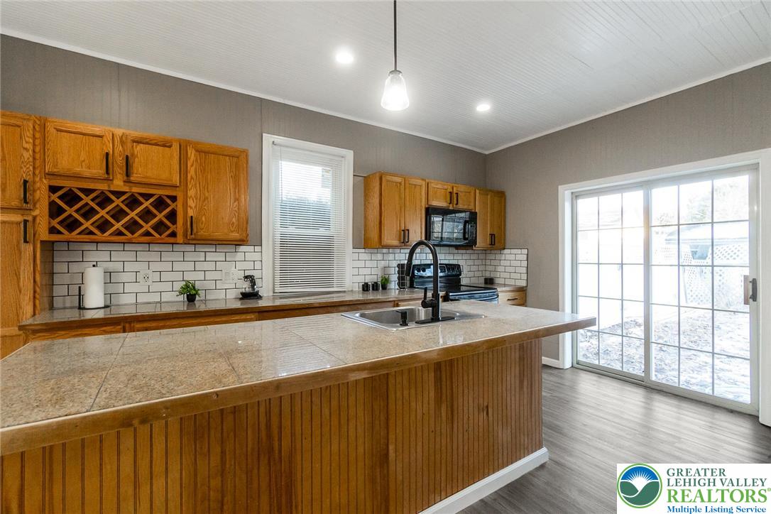 2213 Village Road Orefield, PA 18069 - Photo 29 of 41 a kitchen with stainless steel appliances granite countertop a sink a stove and a wooden cabinets