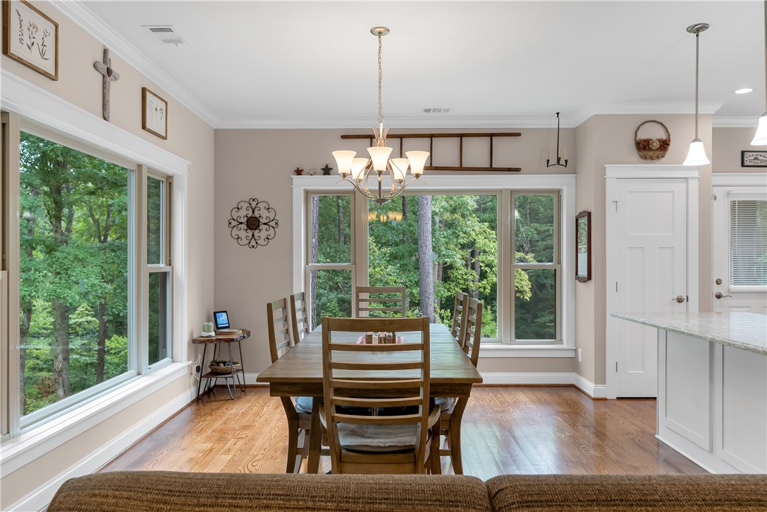 329 High Hampton Road Salem, SC 29676 - Photo 17 of 47 Gleaming hardwood floors and classic crown molding frame a dining space looking out to nature.