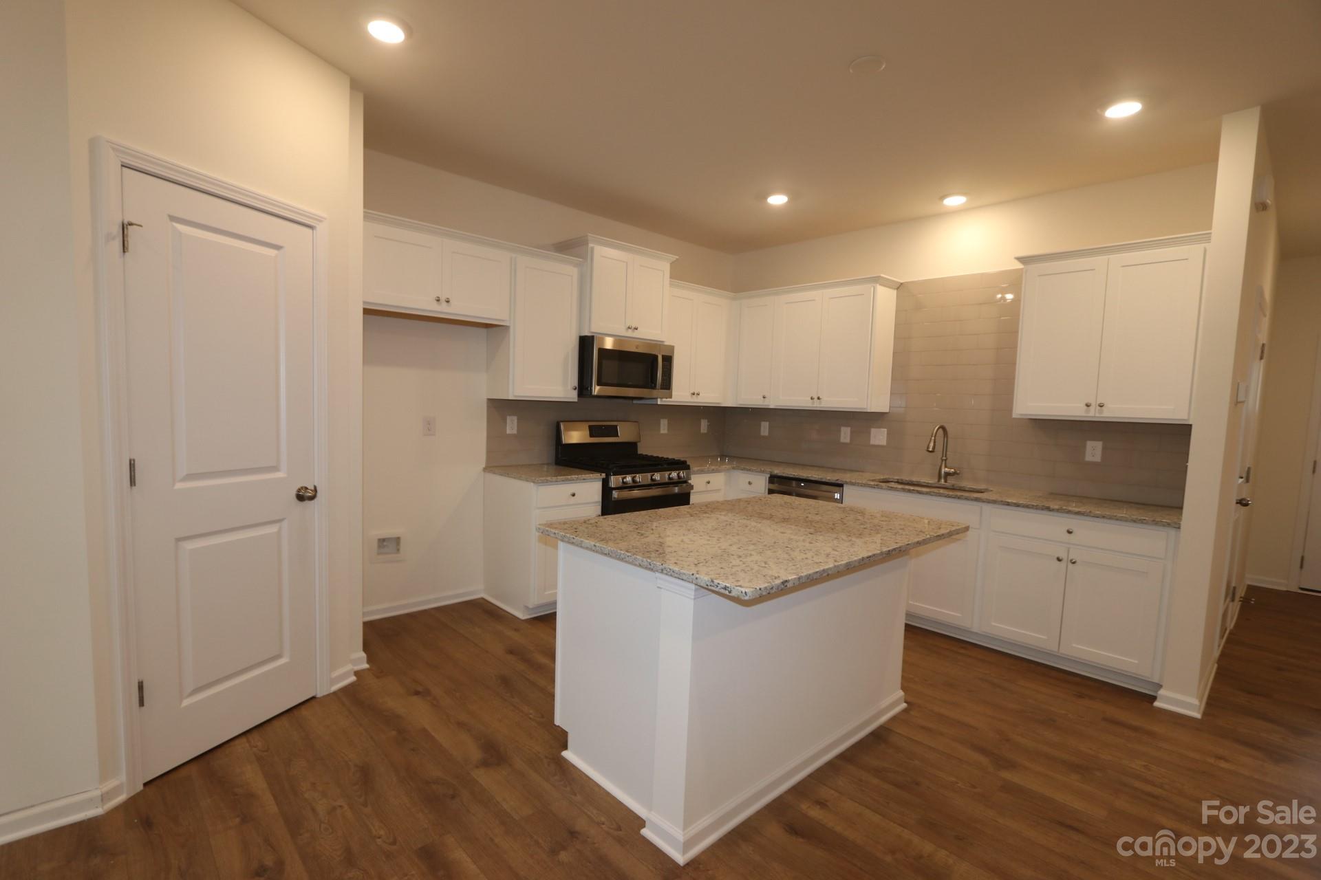 2827 Trinity Street Monroe, NC 28110 - Photo 3 of 5 a kitchen with a sink a stove a microwave and white cabinets