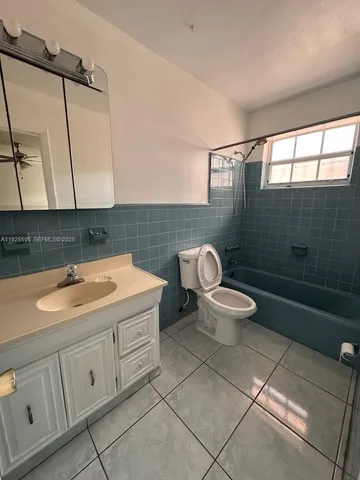 a view of an empty room and chandelier fan