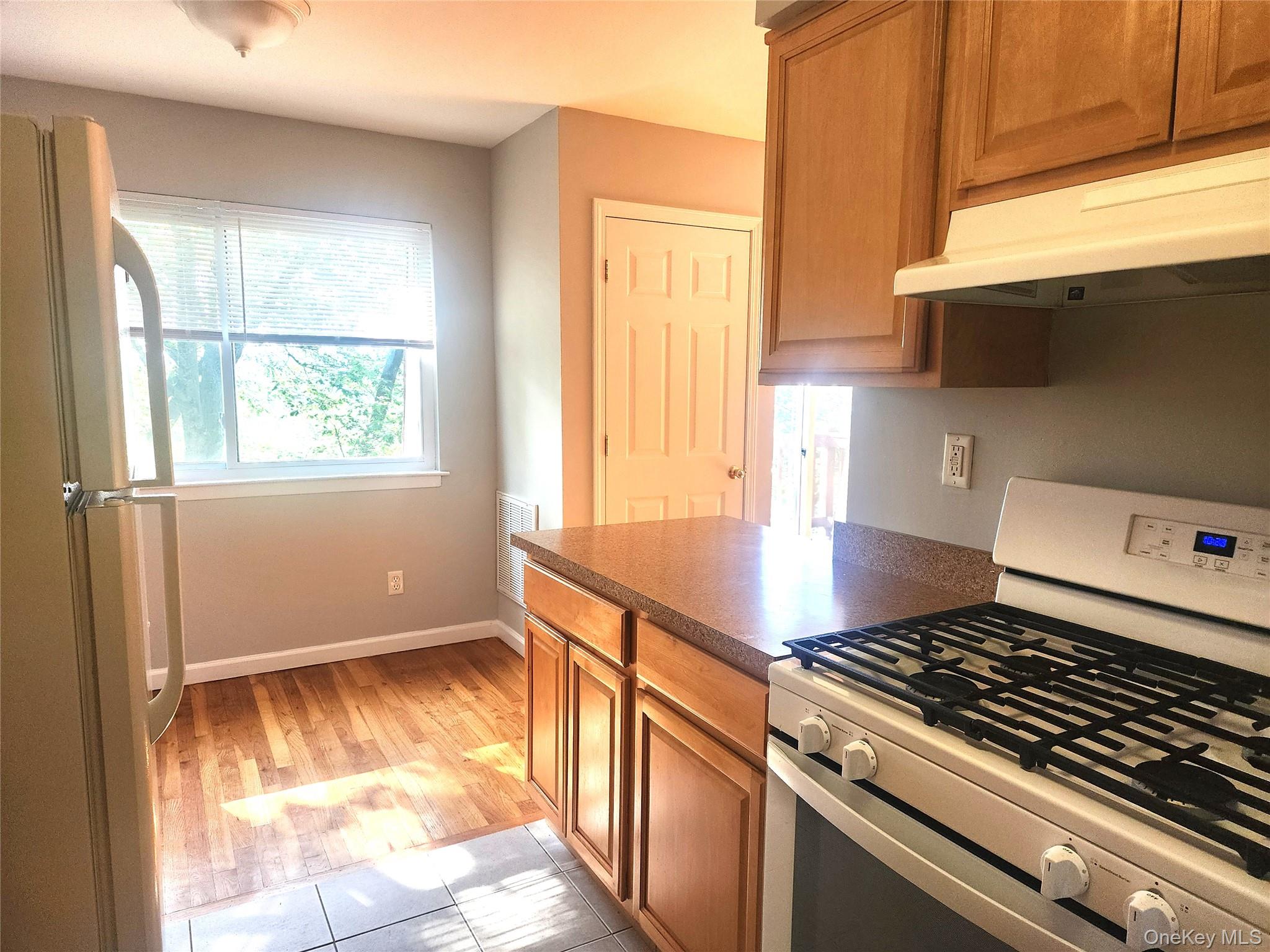 18 Pavilion Ridge Way, Unit 15 Suffern, NY 10901 - Photo 3 of 5 a kitchen with granite countertop a stove a sink and a window