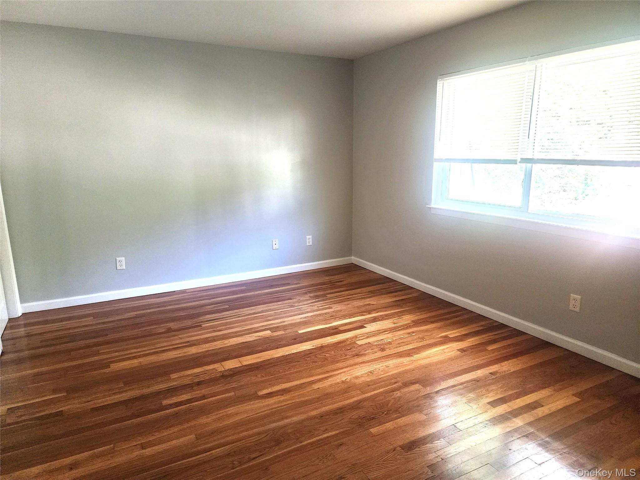 18 Pavilion Ridge Way, Unit 15 Suffern, NY 10901 - Photo 4 of 5 an empty room with wooden floor and windows