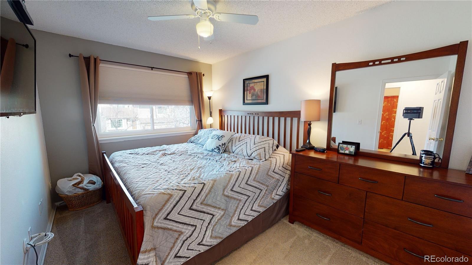 10482 Hyacinth Street Highlands Ranch, CO 80129 - Photo 19 of 40 a bedroom with a bed and a large mirror on the dresser