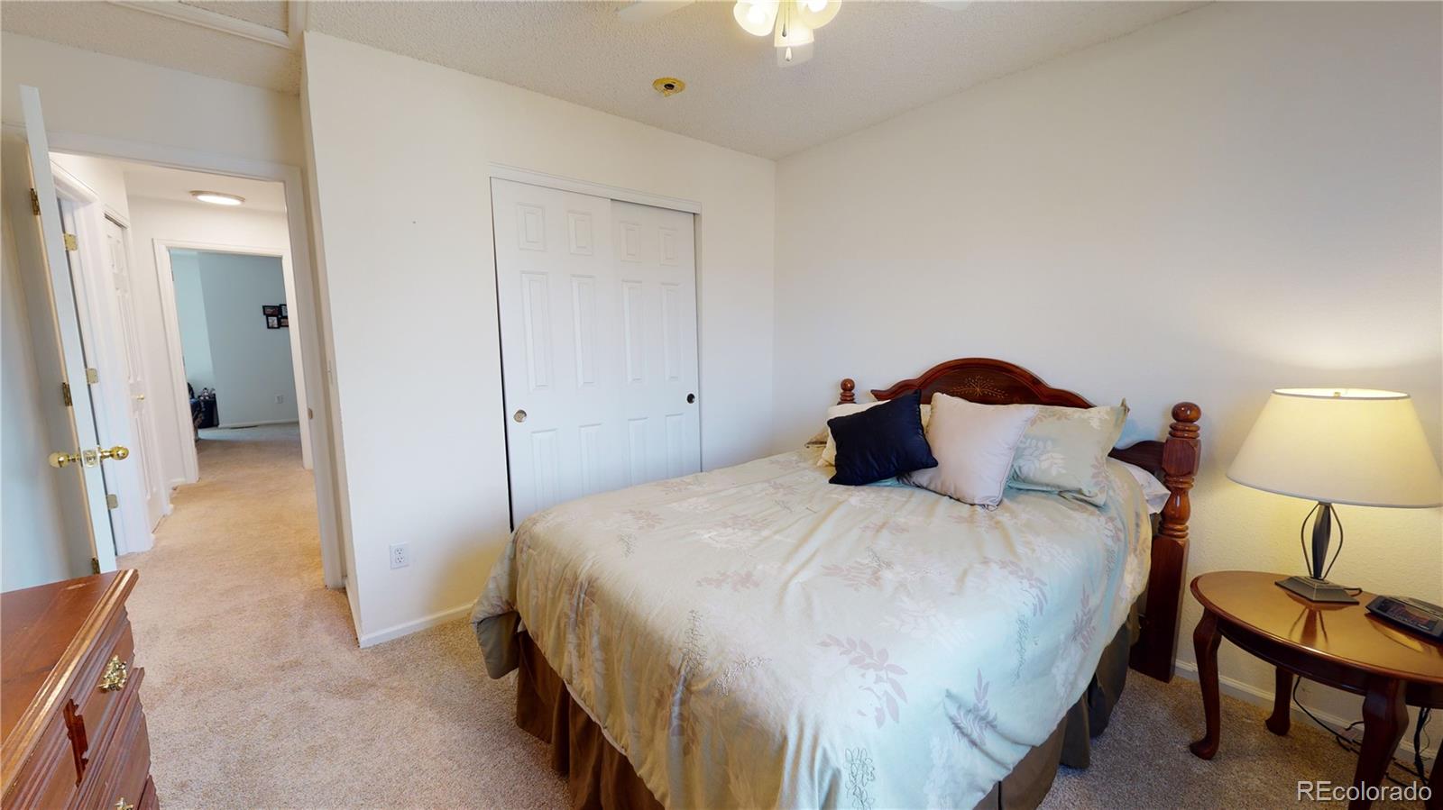 10482 Hyacinth Street Highlands Ranch, CO 80129 - Photo 20 of 40 a bedroom with a bed and a lamp