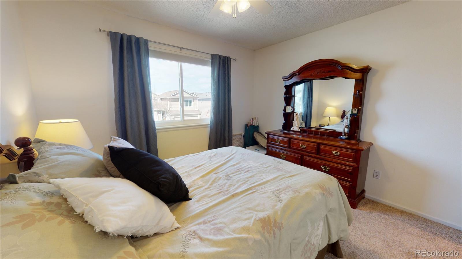 10482 Hyacinth Street Highlands Ranch, CO 80129 - Photo 21 of 40 a bedroom with a bed and a dresser with mirror
