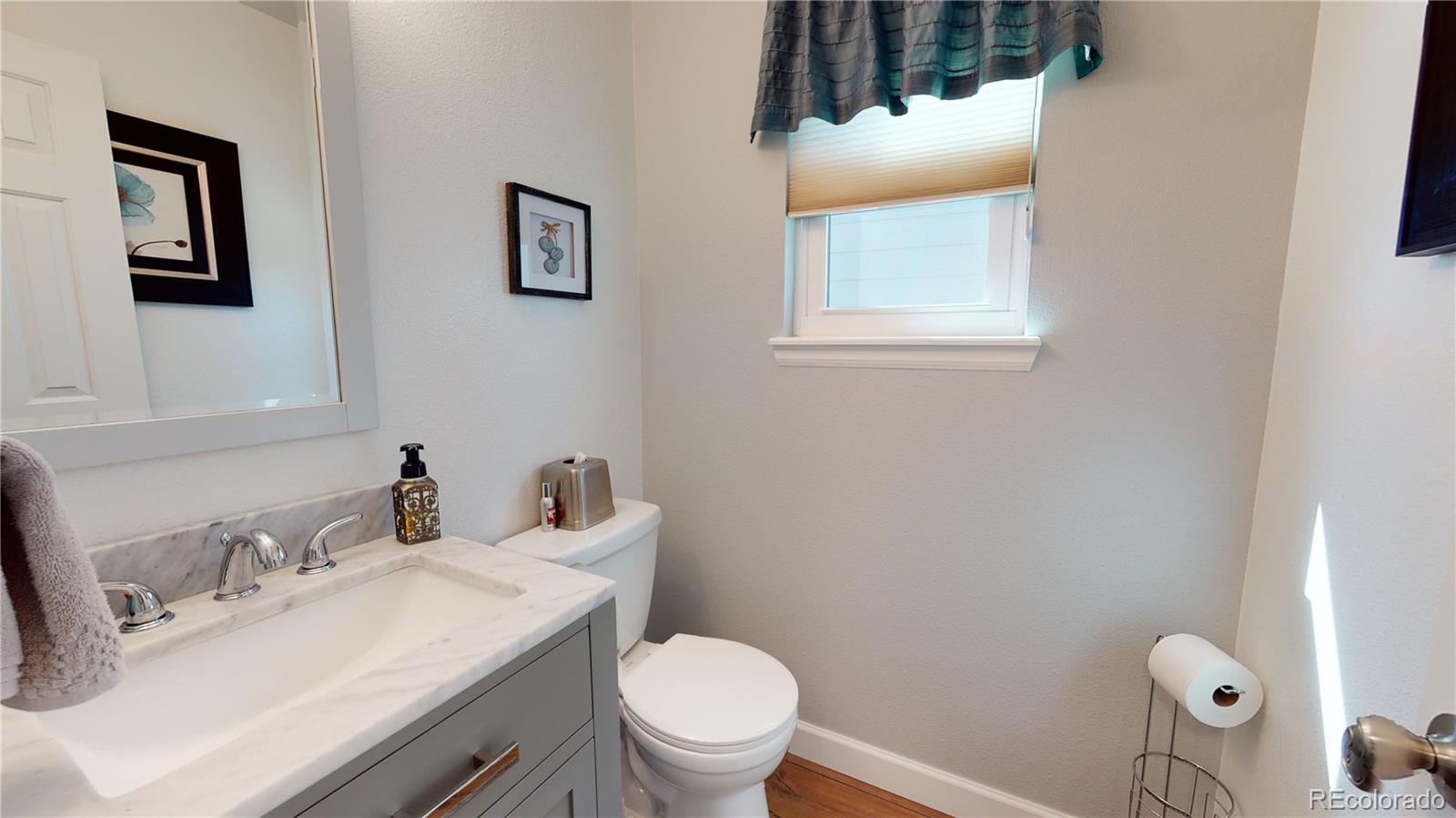 10482 Hyacinth Street Highlands Ranch, CO 80129 - Photo 25 of 40 a bathroom with a toilet sink vanity and mirror