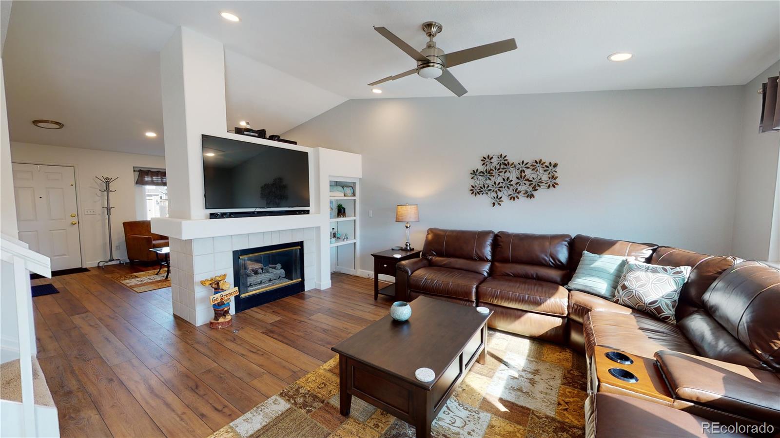 10482 Hyacinth Street Highlands Ranch, CO 80129 - Photo 8 of 40 a living room with furniture a fireplace and a flat screen tv