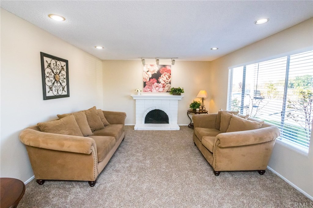 7446 El Morro Way Buena Park, CA 90620 - Photo 4 of 23 a living room with furniture a fireplace and a large window
