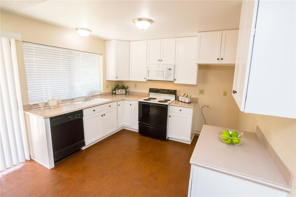 7446 El Morro Way Buena Park, CA 90620 - Photo 8 of 23 a kitchen with a sink a stove cabinets and a window