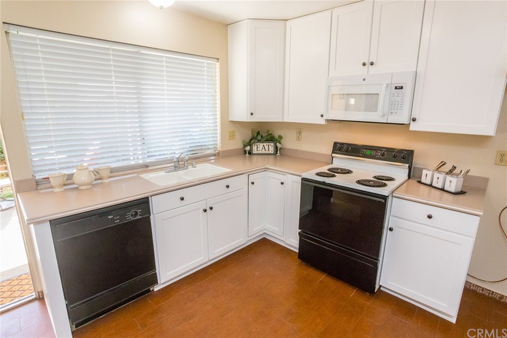 7446 El Morro Way Buena Park, CA 90620 - Photo 9 of 23 a kitchen with white cabinets and white appliances